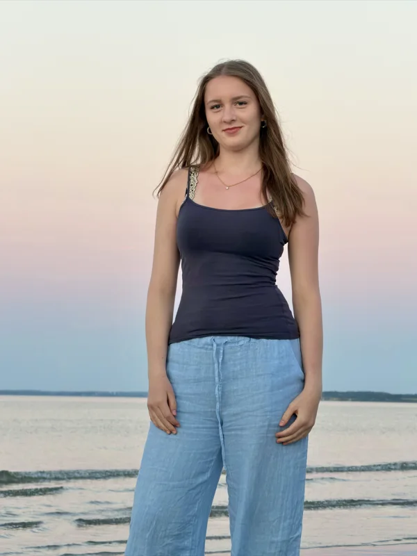 Magdalena Weege am Strand, dunkles Top, helle Leinenhose